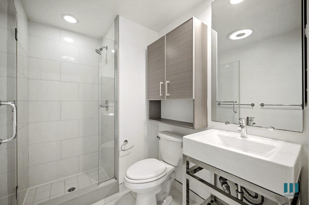 A white toilet sits next to a sink in a modern bathroom.