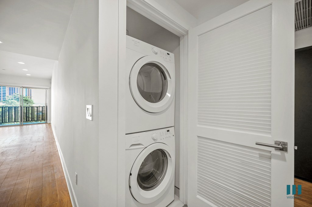 A white washing machine is in a white door.