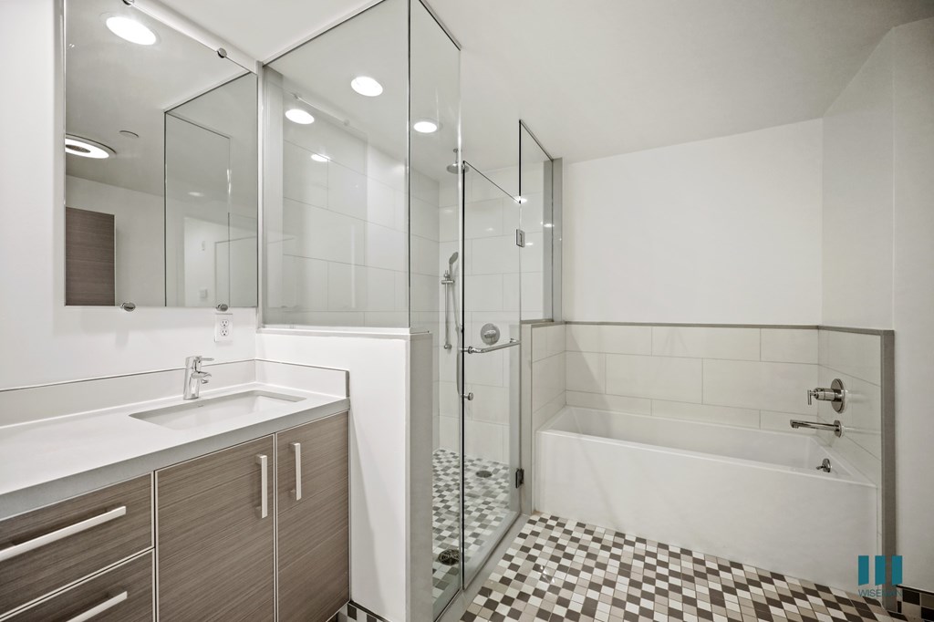 A modern bathroom with a walk-in shower and a sink.