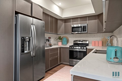a kitchen with stainless steel appliances and white counter tops
