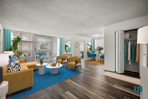 A living room with a yellow couch and a blue rug.