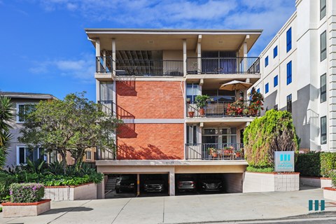A red brick building with a balcony and a sign that says "II".