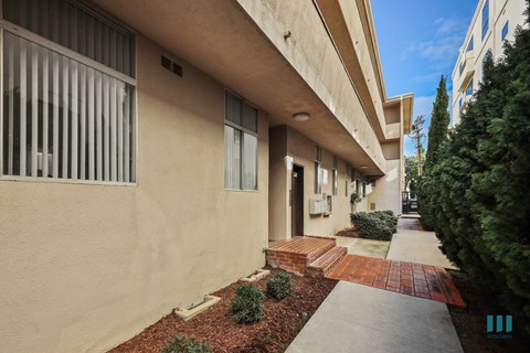 A building with a red brick pathway leading to the entrance.