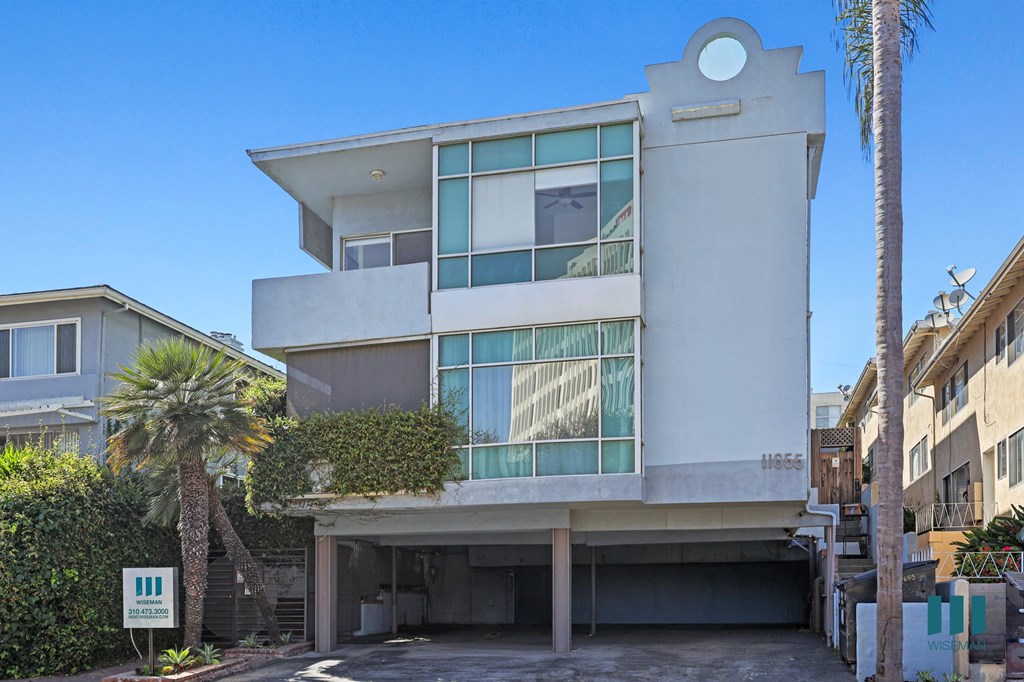 A modern house with a white facade and large windows.
