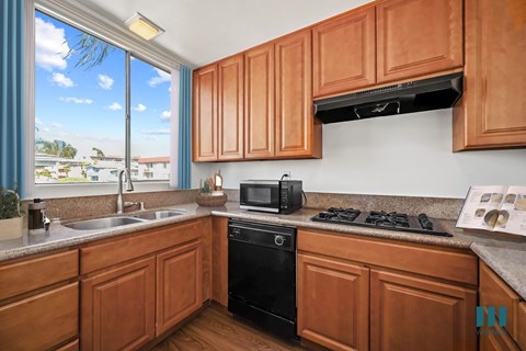 A kitchen with wooden cabinets and black appliances.