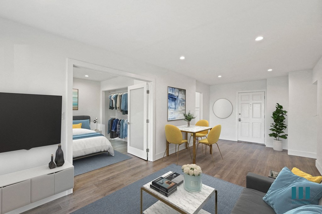 a living room with a tv and a bedroom in the background