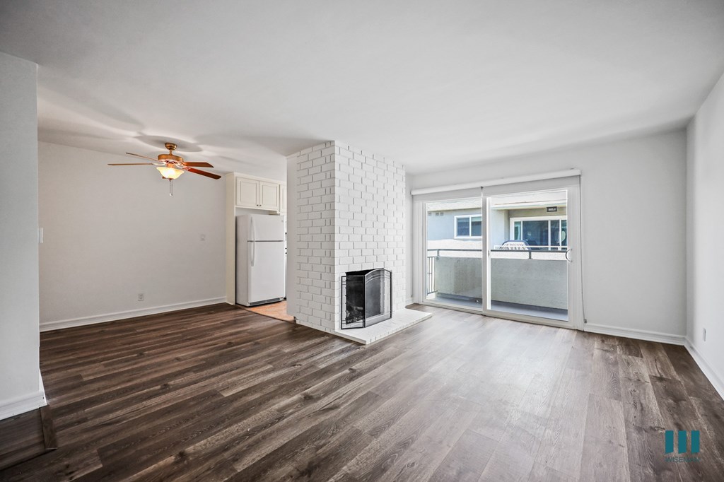 Open-Concept Dining and Living Room with Vinyl Flooring, Fireplace, and Patio