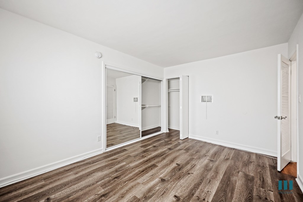Bedroom with Vinly Flooring and Mirrored Closet