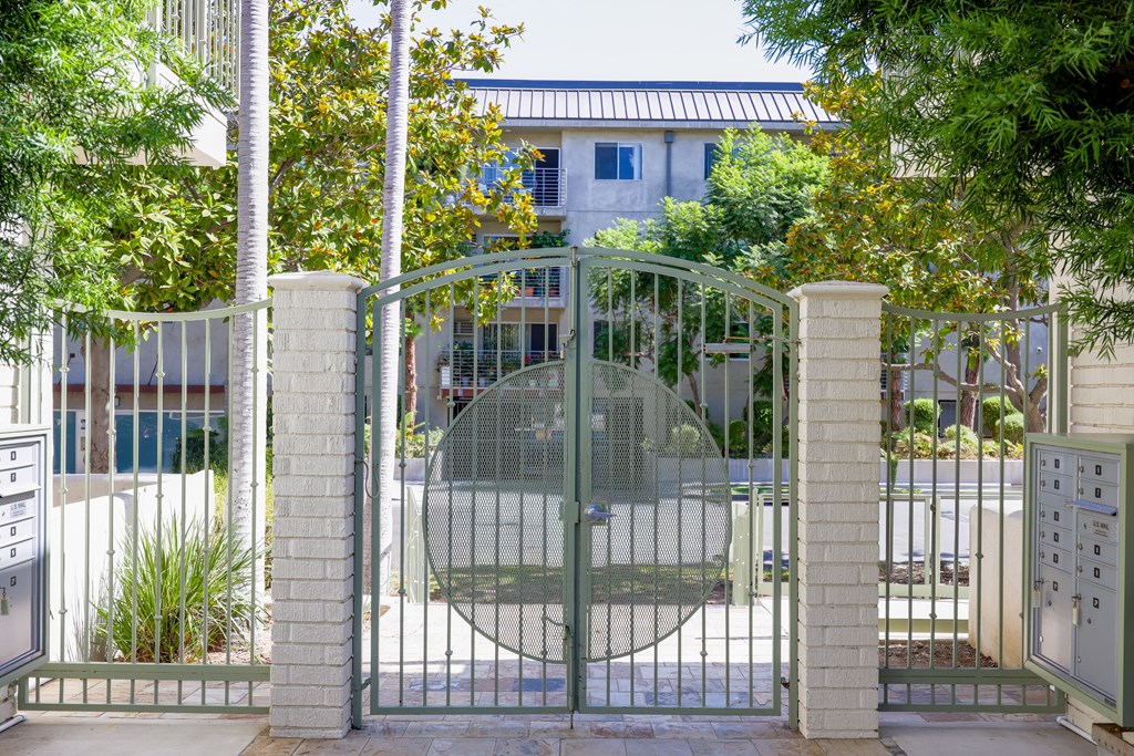 a gate with a house behind it behind a fence