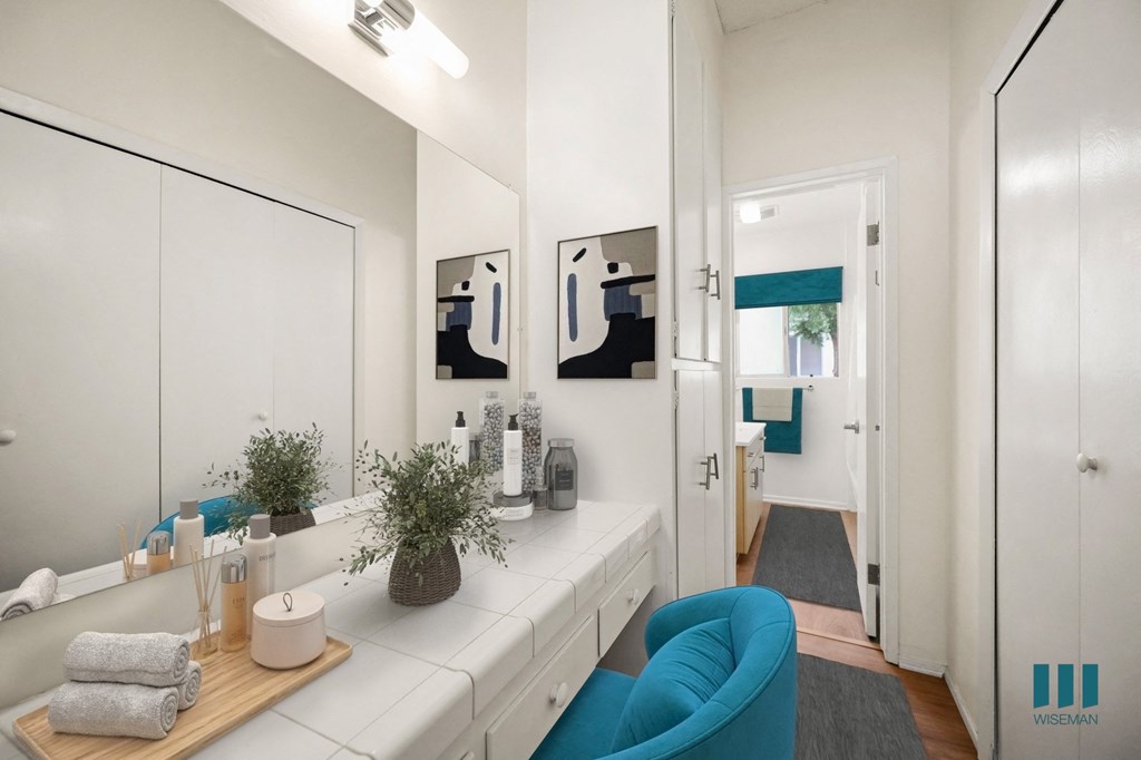 a bathroom with a white counter and a blue chair