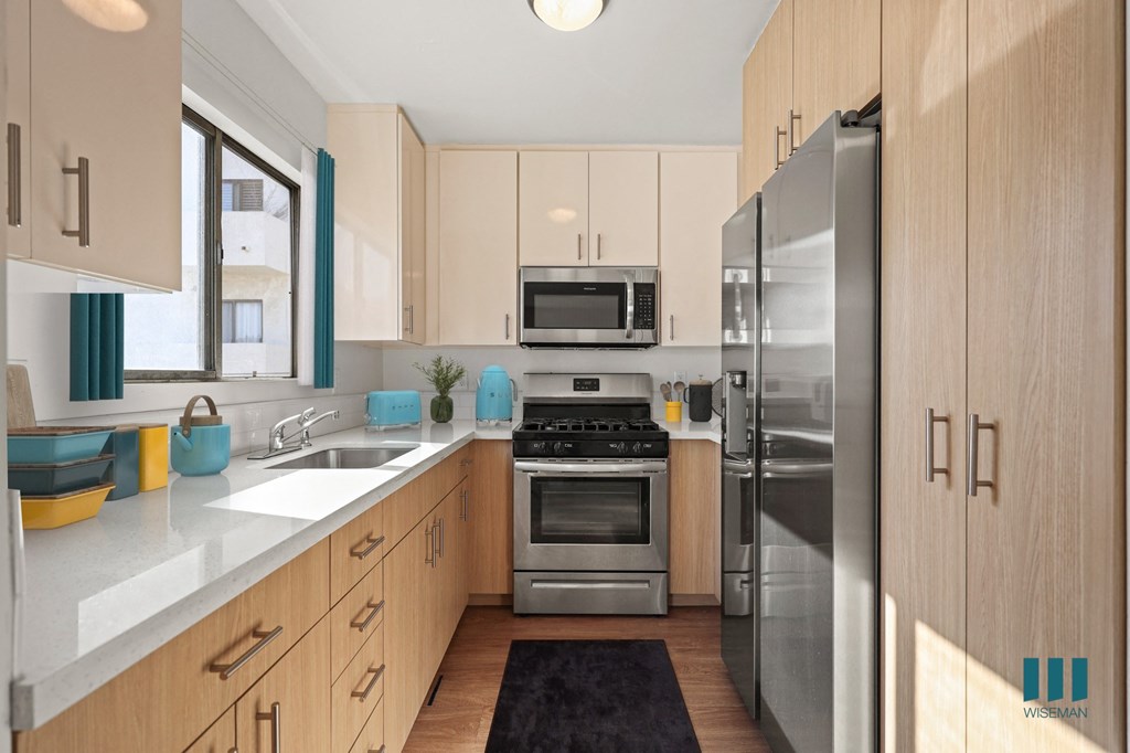 a modern kitchen with stainless steel appliances and white cabinets