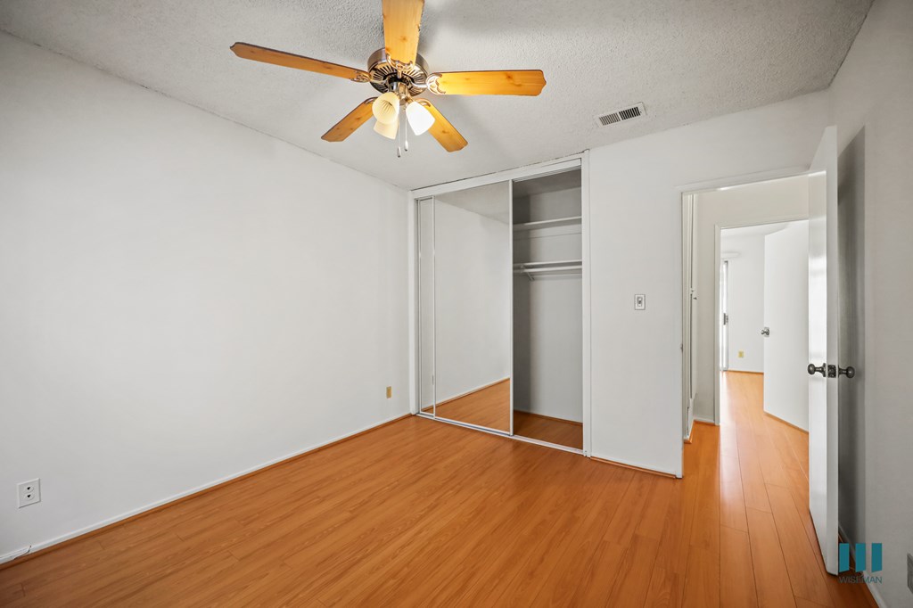 Bedroom with a Closet, Ceiling Fan, and Vinyl Flooring
