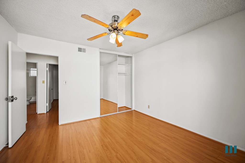 Bedroom with a Closet, Ceiling Fan, and Vinyl Flooring