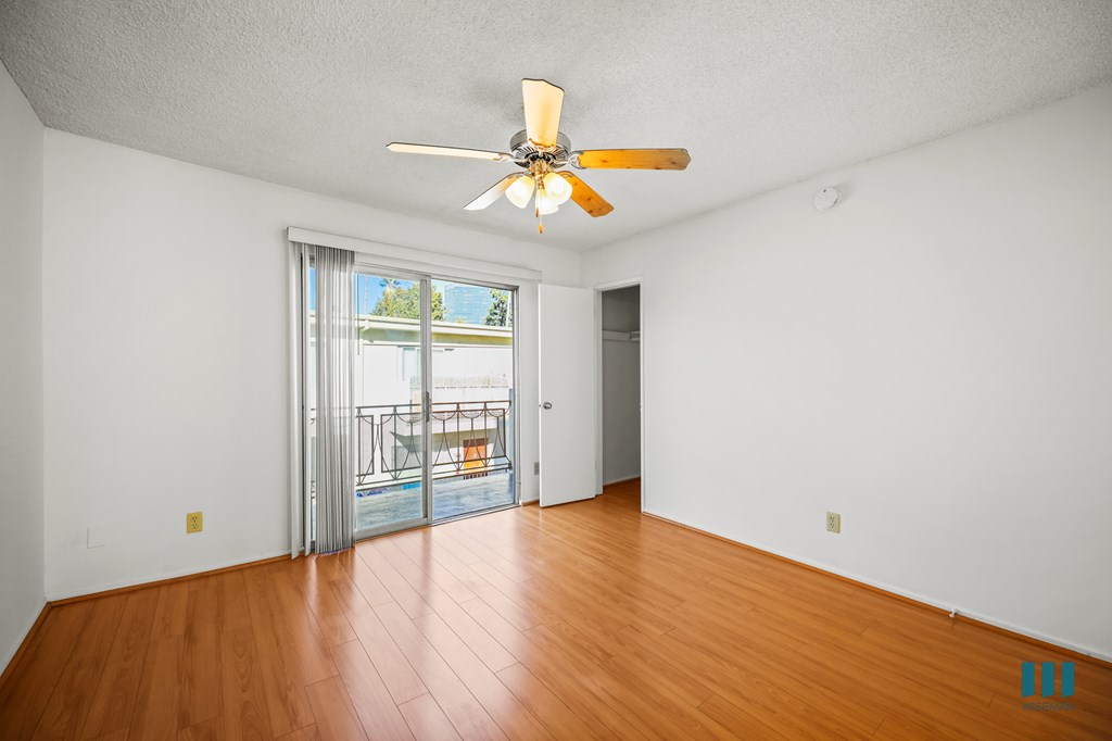 Bedroom with Vinyl Flooring, Ceiling Fan, Closet, and Balcony