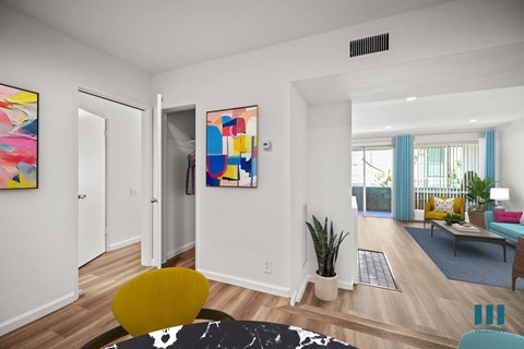 A living room with a yellow chair and a painting on the wall.