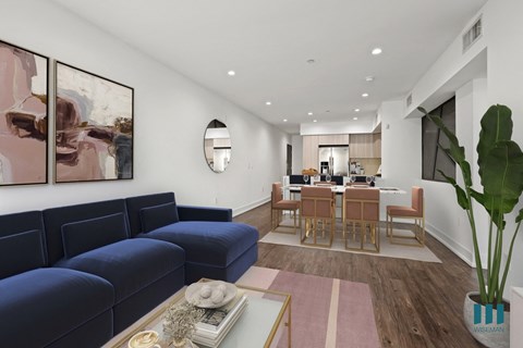 a living room with blue couches and a dining room with a table and chairs