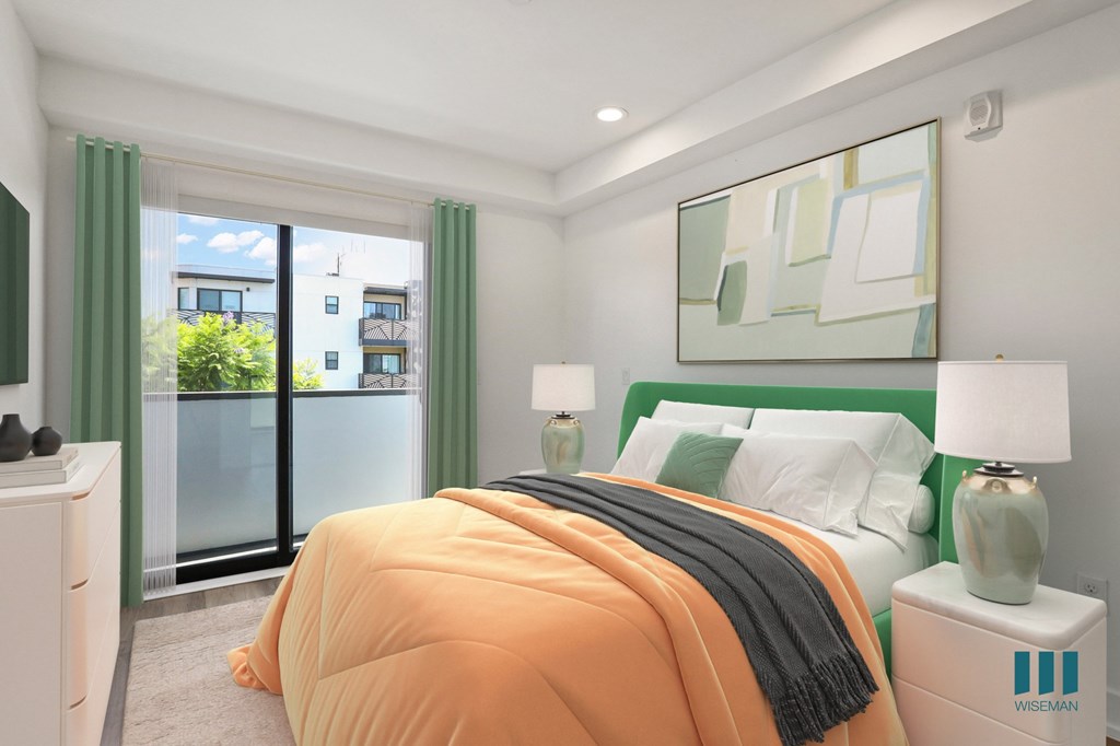 A bedroom with a bed, nightstands, and a window with a view of a building outside.