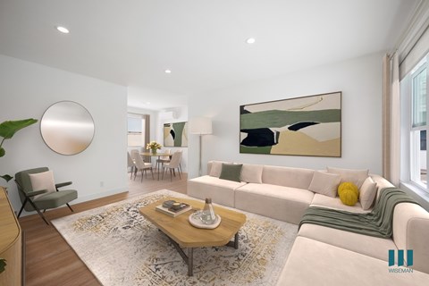 A modern living room with a large painting on the wall and a coffee table in the center.