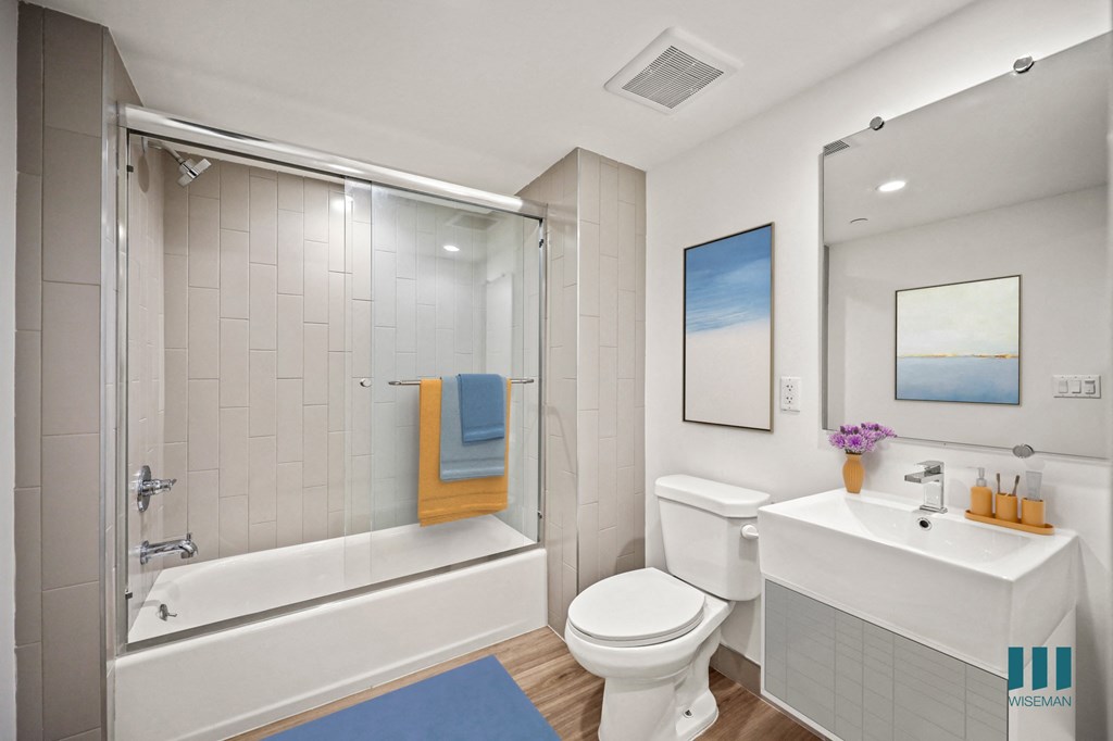 A bathroom with a white toilet, sink, and bathtub.