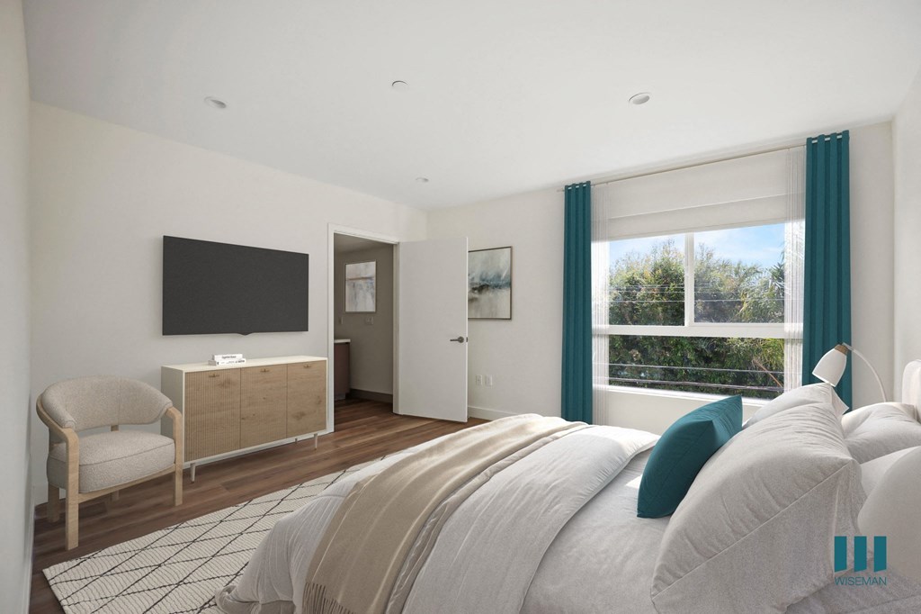 a bedroom with a bed and a tv on the wall