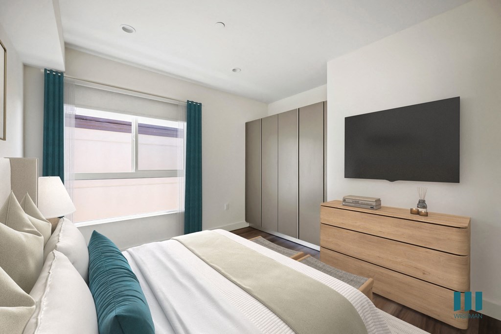 a bedroom with a bed and a tv on the wall