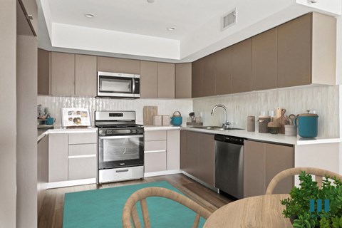 A modern kitchen with brown cabinets and stainless steel appliances.