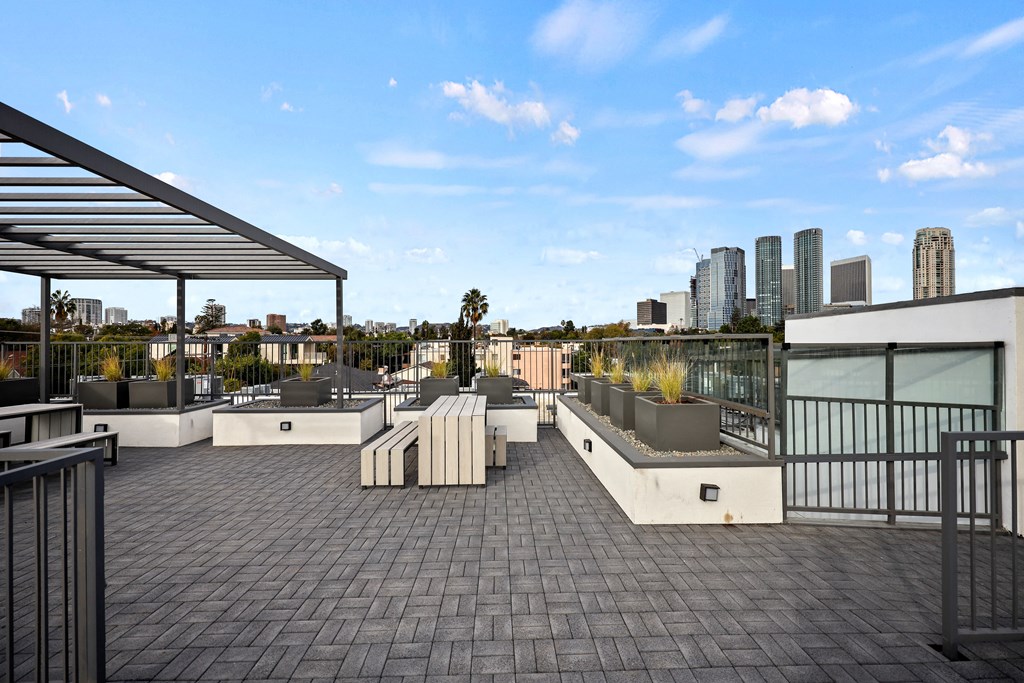 A rooftop patio with a metal railing and a metal awning.