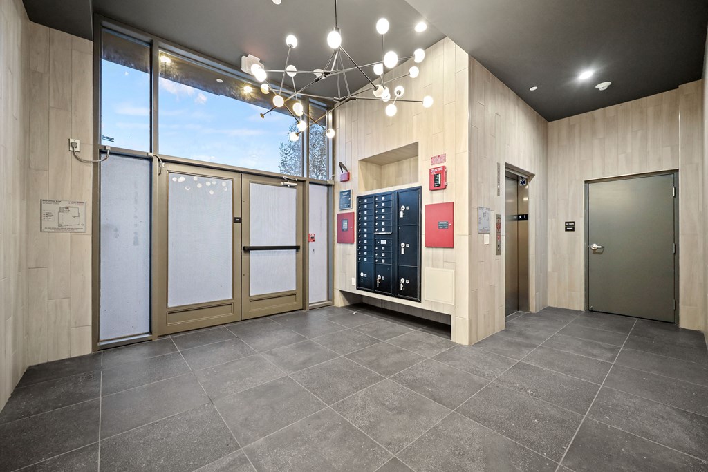 A modern office lobby with a reception desk and a large window.
