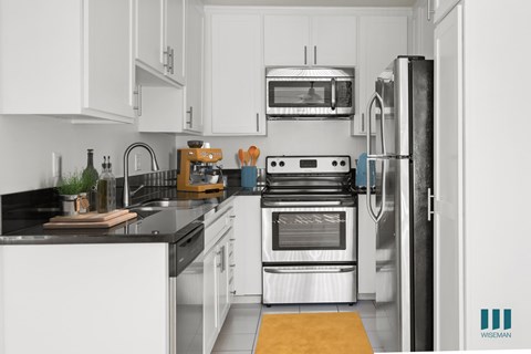 A kitchen with white cabinets and stainless steel appliances.