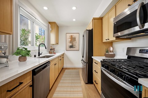 A modern kitchen with wooden cabinets and stainless steel appliances.