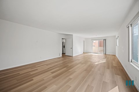 A room with wooden flooring and white walls.