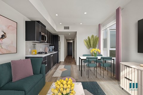 A modern living room with a green couch and a dining table set up.