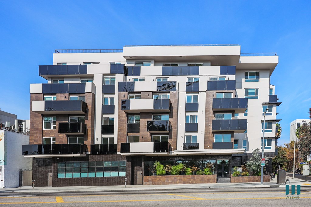 A modern multi-story building with a mix of white and dark facade.
