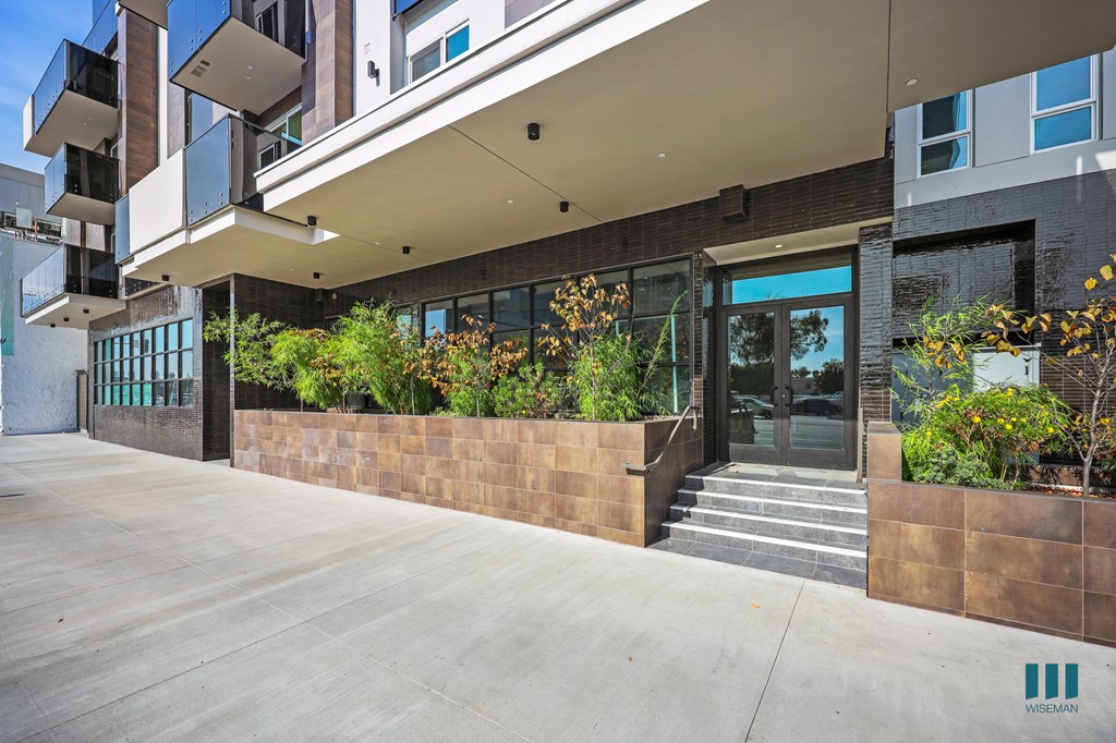 A modern building with a glass entrance and a concrete floor.