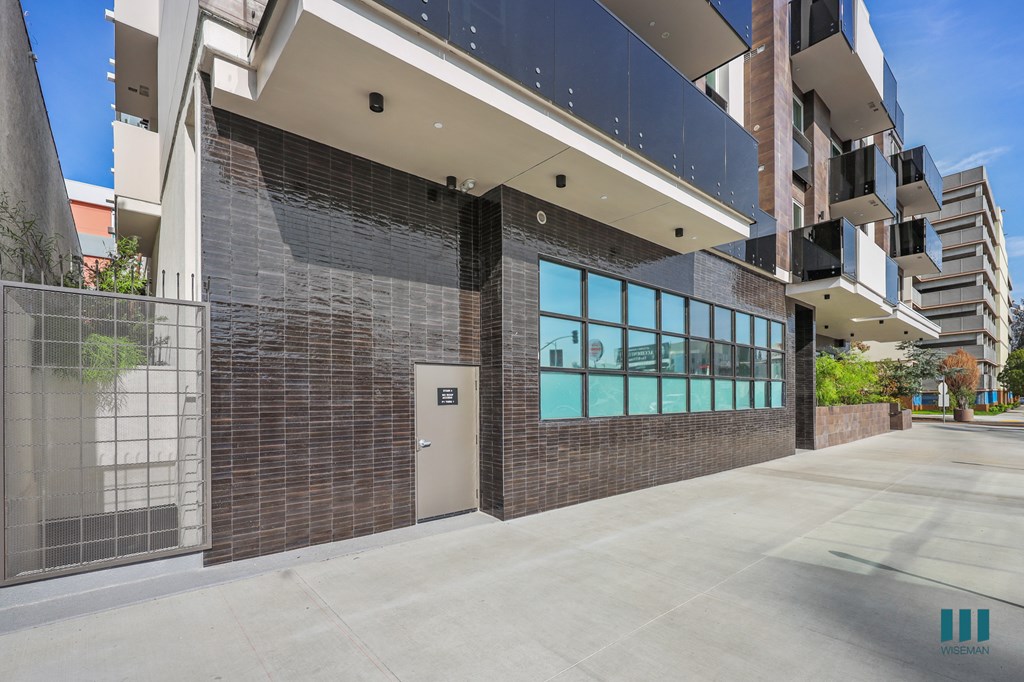 A modern building with a glass facade and a brown brick wall.