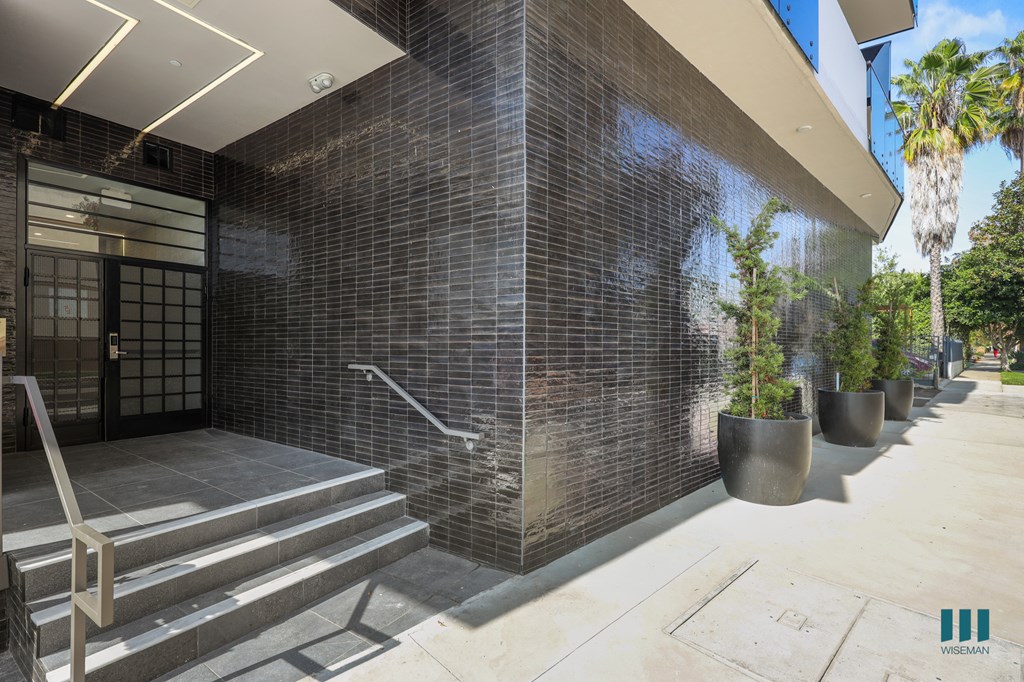 A building with a tiled wall and a set of stairs leading up to it.