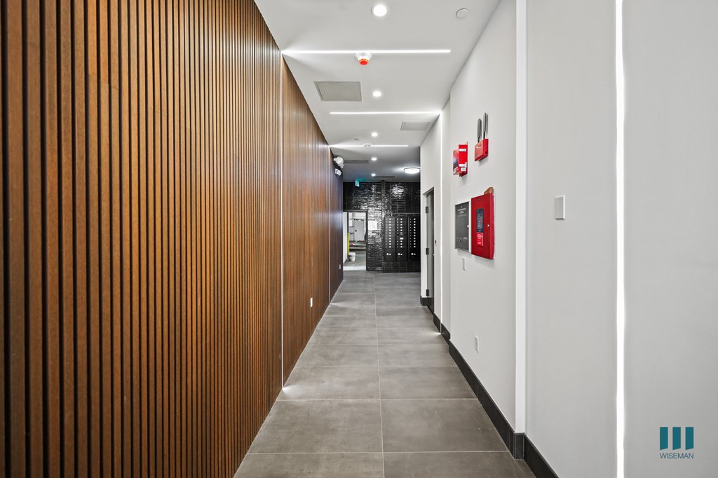 A long hallway with a red fire hydrant on the wall.