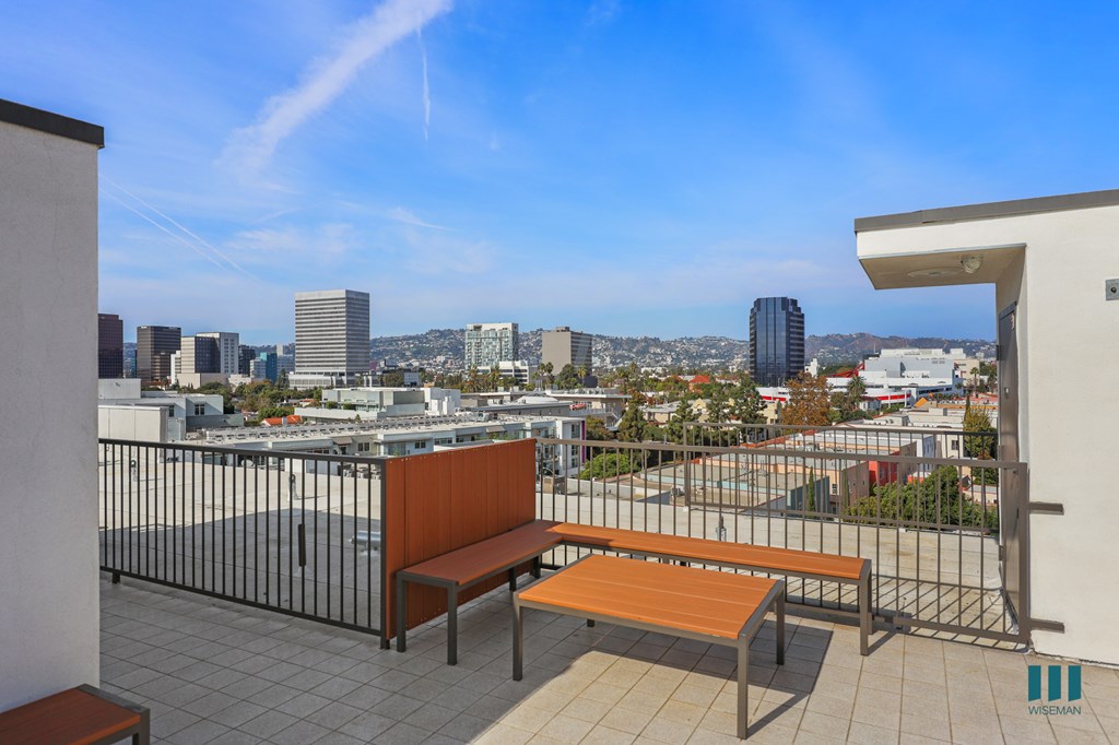 A balcony with a bench and a view of the city.