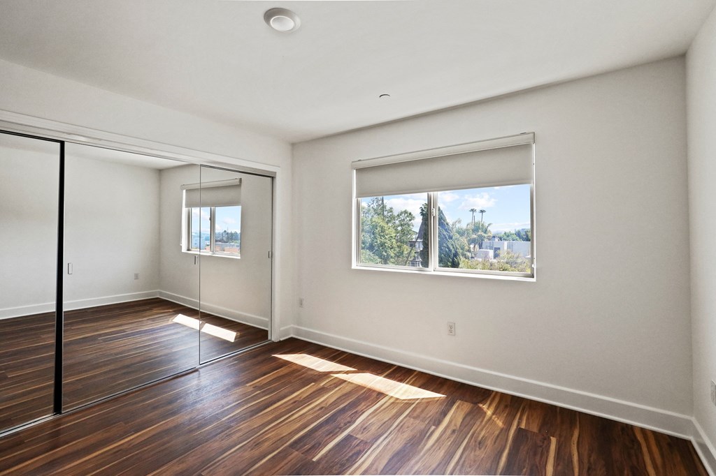 Bedroom with Vinyl Flooring, Mirrored Closet, and Vinyl Flooring