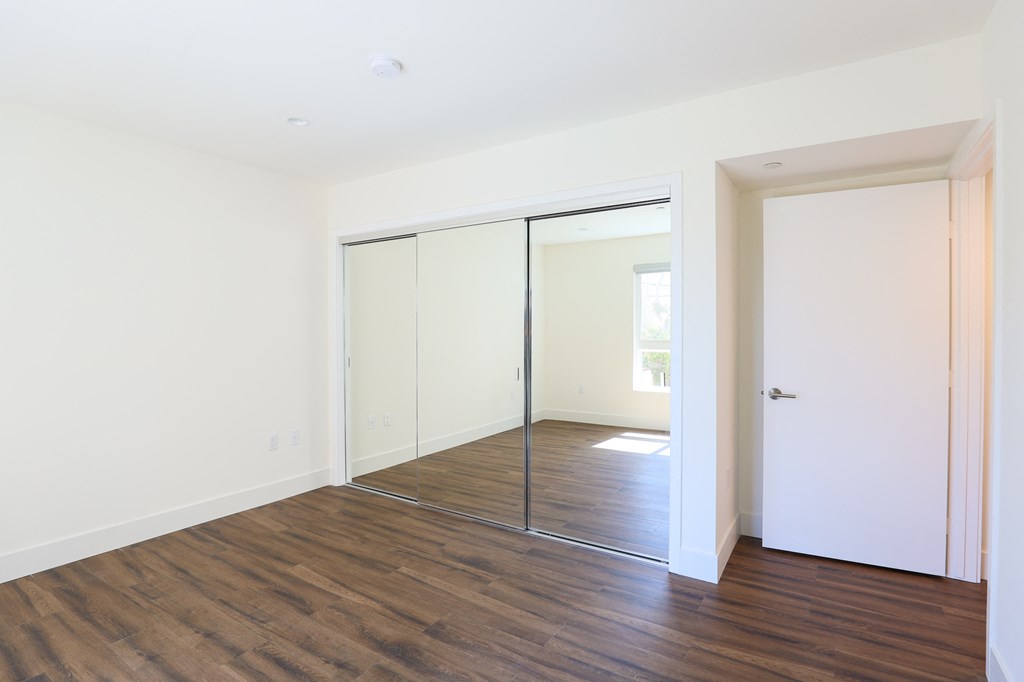 Bedroom with Mirrored Closet and Vinyl Flooring
