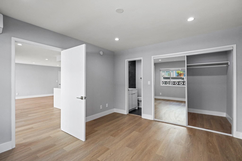 Bedroom with Mirrored Closet, Recessed Lighting, Vinyl Flooring, and Bathroom