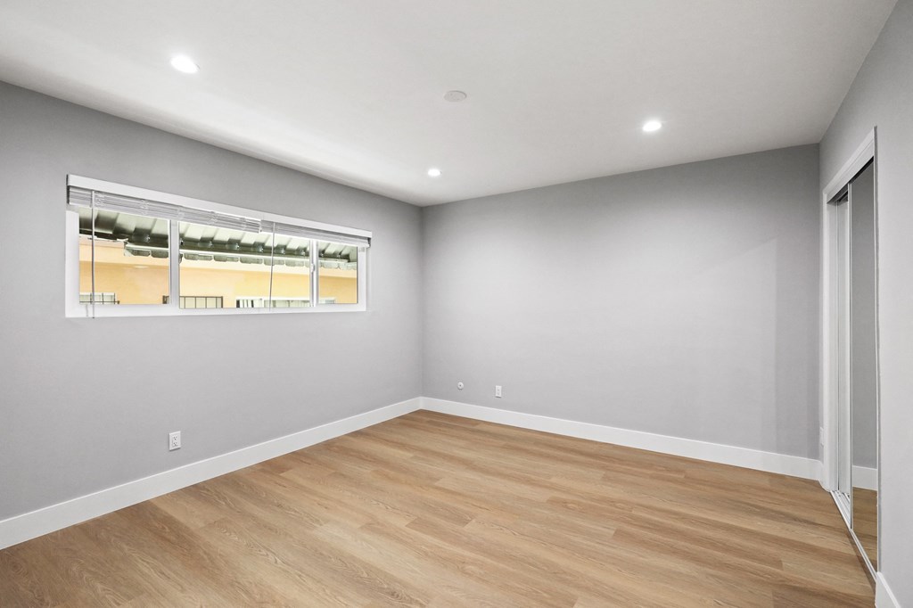 Bedroom with Mirrored Closet, Vinyl Flooring, Window, and Recessed Lighting