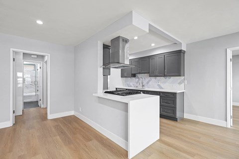 a white kitchen with black cabinets and a white island