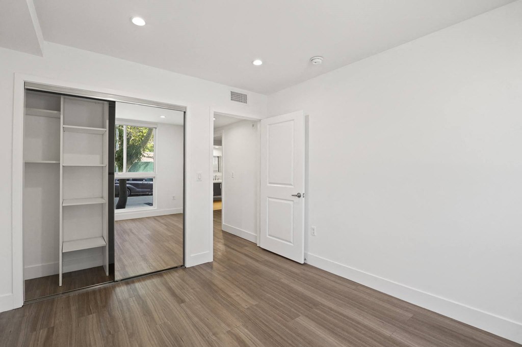 Bedroom with Mirrored Closet with Shelving, Recessed Lighting, and Vinyl Floors