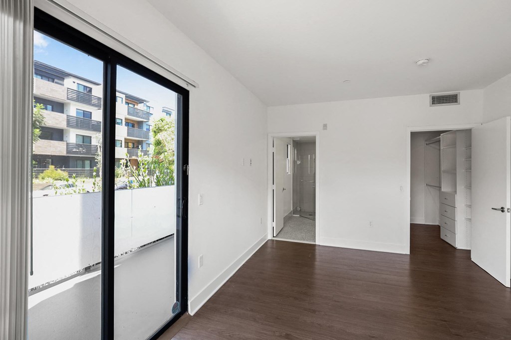 Bedroom with Walk-In Closet with Built-In Organizers and a Bathroom