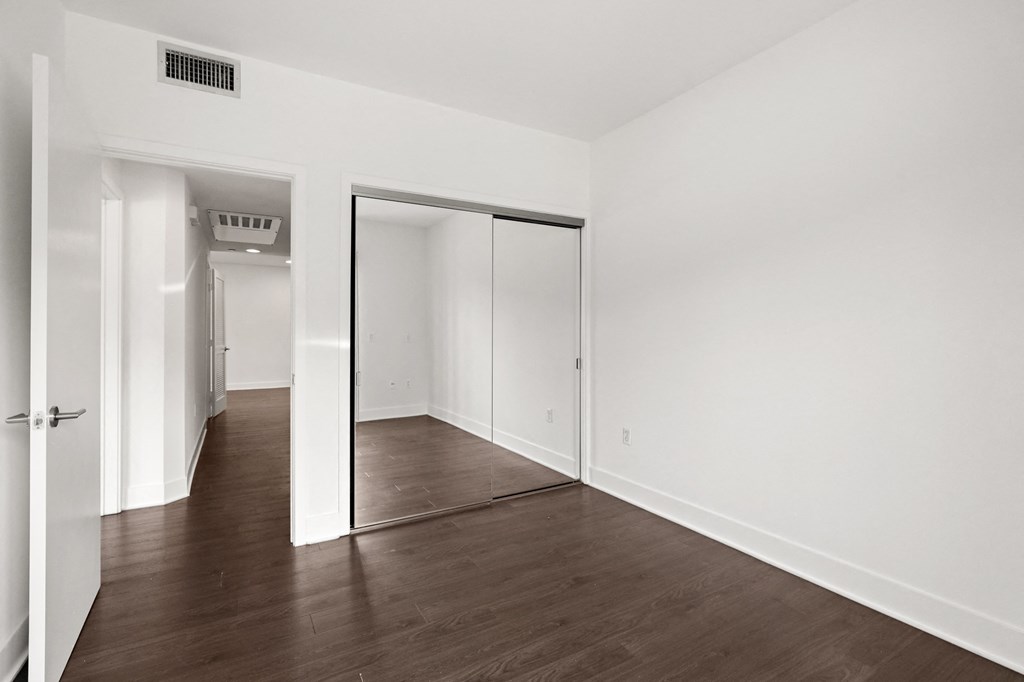 Bedroom with Mirrored Closet and Vinyl Flooring