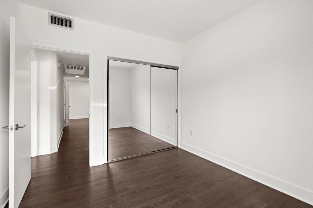 Bedroom with Large Mirrored Closet and Vinyl Flooring