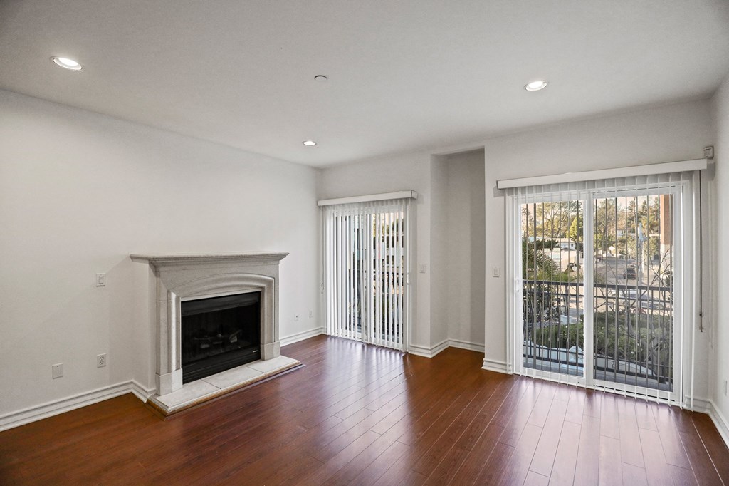 Living Room Area with an Electric Fireplace,  Vinyl Flooring, and Balcony