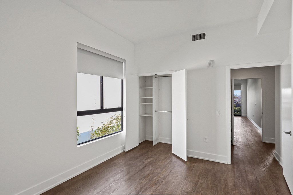 Bedroom with Windows with Shades and Closet with Built-In Shelving