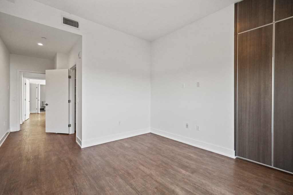 Bedroom with Vinyl Flooring, Bathroom, and Built-In Storage Cabinets